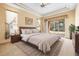Spacious bedroom featuring tray ceilings, a large bed, and sliding glass doors offering a tranquil view of the outdoors at 1330 Misty Greens Dr, Sun City Center, FL 33573