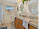 Bathroom with double sinks, oak cabinets, tile flooring and a window for natural light at 2533 Duncan Dr, Belleair Bluffs, FL 33770