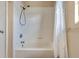 Bathroom with a white tiled tub and shower combination with a white shower curtain at 2533 Duncan Dr, Belleair Bluffs, FL 33770