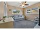 Cozy living room with a comfortable blue sofa, two windows offering natural light, and neutral walls at 2533 Duncan Dr, Belleair Bluffs, FL 33770
