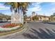 Elegant community entrance with lush landscaping and a grand sign welcomes you to a luxurious living experience at 2765 Via Cipriani # 1232B, Clearwater, FL 33764