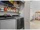 Convenient laundry room with washer, dryer, and storage shelves located near the bedroom at 2765 Via Cipriani # 1232B, Clearwater, FL 33764