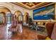 Elegant lobby with marble floors, arched doorways, comfortable seating, and a large scenic painting adds a touch of sophistication at 2765 Via Cipriani # 1232B, Clearwater, FL 33764