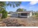 View of the home's exterior showcasing an enclosed porch in the backyard at 3108 Ash Ct, Dunedin, FL 34698