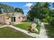 Backyard area featuring lush green lawn, a swing set, mature trees, and a sliding glass door at 651 Southwest N Blvd, St Petersburg, FL 33703
