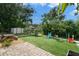 Backyard featuring a paver patio, artificial turf, picnic table, shed, slide and swing set at 651 Southwest N Blvd, St Petersburg, FL 33703