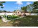 Lush backyard featuring manicured lawn, seating area, a swing set, mature trees, and a white fence at 651 Southwest N Blvd, St Petersburg, FL 33703