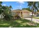 Cozy single-Gathering home featuring a well-manicured lawn, mature palm trees, and a single-car garage at 651 Southwest N Blvd, St Petersburg, FL 33703
