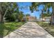 Inviting single-story home with a long driveway, green lawn, mature trees and well maintained landscaping at 651 Southwest N Blvd, St Petersburg, FL 33703