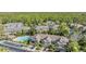 Aerial view of community townhomes, community pool, and lush greenery near a wooded area at 12537 Silverdale St, Tampa, FL 33626