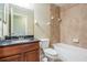 Bathroom features wood vanity with dark countertop, tiled shower-tub, toilet, and a large mirror at 12537 Silverdale St, Tampa, FL 33626