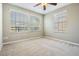 Bright bedroom with neutral walls, carpet, ceiling fan and three windows allowing ample natural light at 12537 Silverdale St, Tampa, FL 33626