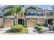 A view of the townhome's exterior showcasing a well-manicured lawn, a tan garage, and lovely curb appeal at 12537 Silverdale St, Tampa, FL 33626