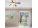 Bright living room with beige walls, ceiling fan, sliding glass doors, and a window at 12537 Silverdale St, Tampa, FL 33626