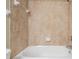 Close up of a shower tub with tan tiled walls and a white tub at 12537 Silverdale St, Tampa, FL 33626
