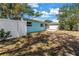 Backyard of home with a white fence and green and leafy trees at 13851 102Nd Ave, Largo, FL 33774