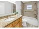 This bathroom boasts granite counters, wood cabinets, and tiled shower with grab bars for safety at 13851 102Nd Ave, Largo, FL 33774
