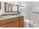 This bathroom boasts granite counters, wood cabinets, and a tiled shower with grab bars for safety at 13851 102Nd Ave, Largo, FL 33774