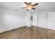 This room features wood flooring, a ceiling fan, and access to another room through a white door at 13851 102Nd Ave, Largo, FL 33774