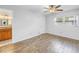 Minimalist bedroom features wood-look floors, a ceiling fan, and a view of the bathroom at 13851 102Nd Ave, Largo, FL 33774