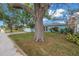 Attractive single story blue house featuring manicured landscaping, and a paved driveway on a sunny day at 13851 102Nd Ave, Largo, FL 33774