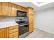 Kitchen features a modern black range and microwave along with wood cabinets and tile floors at 13851 102Nd Ave, Largo, FL 33774