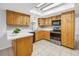 Well-lit kitchen featuring tile floors, light wood cabinets, white countertops, and modern black appliances at 13851 102Nd Ave, Largo, FL 33774