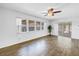 Bright living room boasts wood-look floors, a ceiling fan, and access to a screened-in porch at 13851 102Nd Ave, Largo, FL 33774