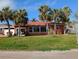 Cozy single-story home featuring a well-manicured lawn and tropical palm trees at 15806 Redington Dr, Redington Beach, FL 33708