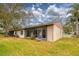 Exterior view showcasing a screened-in porch and lush backyard landscaping at 20 Sylvia Pl, Oldsmar, FL 34677