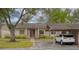 Inviting exterior of a cozy home with a carport and mature landscaping, including an American flag at 20 Sylvia Pl, Oldsmar, FL 34677