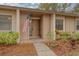 Charming front entrance to the home features an American flag, neat landscaping, and a welcoming front door at 20 Sylvia Pl, Oldsmar, FL 34677