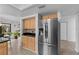Modern kitchen featuring stainless steel refrigerator, wooden cabinets, and sleek black countertops at 20 Sylvia Pl, Oldsmar, FL 34677