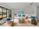 Bright living room featuring stylish wicker furniture, vibrant blue pillows, and a welcoming atmosphere at 20 Sylvia Pl, Oldsmar, FL 34677