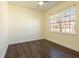 Empty bedroom with dark hardwood floors and natural light from a window at 6816 Dali Ave # E206, Land O Lakes, FL 34637