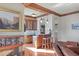 Open-concept bar with wood cabinets, stone countertops, mosaic backsplash, and seating for two at 1097 Eden Isle Ne Dr, St Petersburg, FL 33704