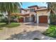 Stately home with a red tile roof, arched entryway, three-car garage, and beautifully paved driveway at 1097 Eden Isle Ne Dr, St Petersburg, FL 33704
