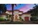 Elegant two-story home featuring a red tile roof, manicured landscaping, and a spacious driveway at 1097 Eden Isle Ne Dr, St Petersburg, FL 33704