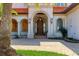 Elegant front entryway showcasing stone detailing, an arched entrance, and lush landscaping at 1097 Eden Isle Ne Dr, St Petersburg, FL 33704