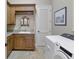 Laundry room includes a sink, storage cabinets, and laundry machine at 1097 Eden Isle Ne Dr, St Petersburg, FL 33704