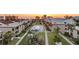 Overhead view of condo complex featuring a pool and verdant common grounds at sunset at 19725 Gulf Blvd # 405, Indian Shores, FL 33785