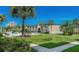 Beautifully landscaped grounds with a pool and palm trees surrounding the building at 19725 Gulf Blvd # 405, Indian Shores, FL 33785