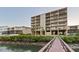 Building exterior with a wooden walkway extending to the water's edge at 19725 Gulf Blvd # 405, Indian Shores, FL 33785