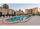 Community pool with lounge chairs and umbrellas surrounded by condo buildings and landscaping at 19725 Gulf Blvd # 405, Indian Shores, FL 33785