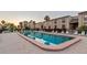 A serene community pool with lounge chairs, umbrellas, and reflection of buildings in the water at 19725 Gulf Blvd # 405, Indian Shores, FL 33785