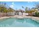 Lush backyard with a sparkling pool and tiki hut, creating a private oasis for relaxation and entertaining at 210 Lee St, Oldsmar, FL 34677