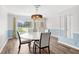 Well-lit dining room with a modern chandelier and a view of the front yard and neighborhood at 210 Lee St, Oldsmar, FL 34677