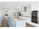 Bright kitchen with a large island, white cabinets, modern appliances, and tiled backsplash at 210 Lee St, Oldsmar, FL 34677