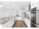 Modern kitchen with white cabinets, stainless steel appliances, granite counters, and wood-style flooring at 210 Lee St, Oldsmar, FL 34677