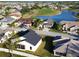 An aerial view of a neighborhood featuring beautiful homes surrounding a golf course and lake on a sunny day at 24156 Buckingham Way, Punta Gorda, FL 33980